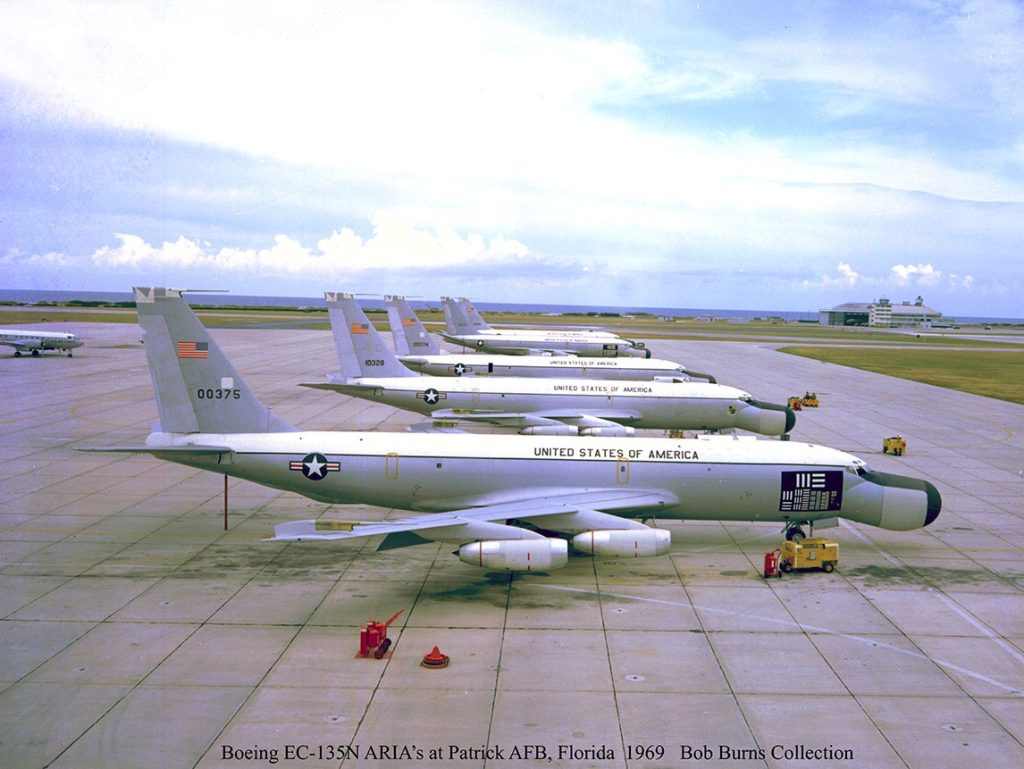 Línea de vuelo de aviones Boeing EC-135N ARIA en Patrick AFB en 1969. Nótese que dos aviones cuentan con marcas de calibración justo encima del tren de aterrizaje delantero. Asimismo, el más cercano cuenta con un recuadro negro con marcas blancas para calibración de los sensores ópticos. Fuente: Bob Burns Collection.