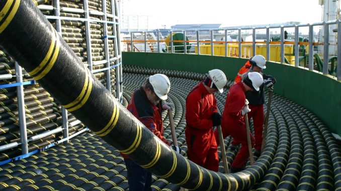 Técnicos trabajando en el despliegue de cables submarinos de electricidad